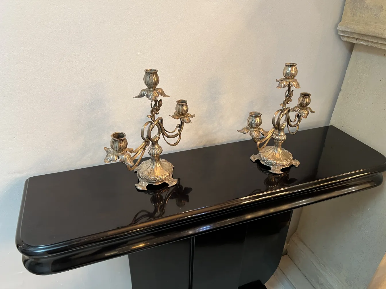 dos candelabros antiguos art nouveau sobre una mesa negra
