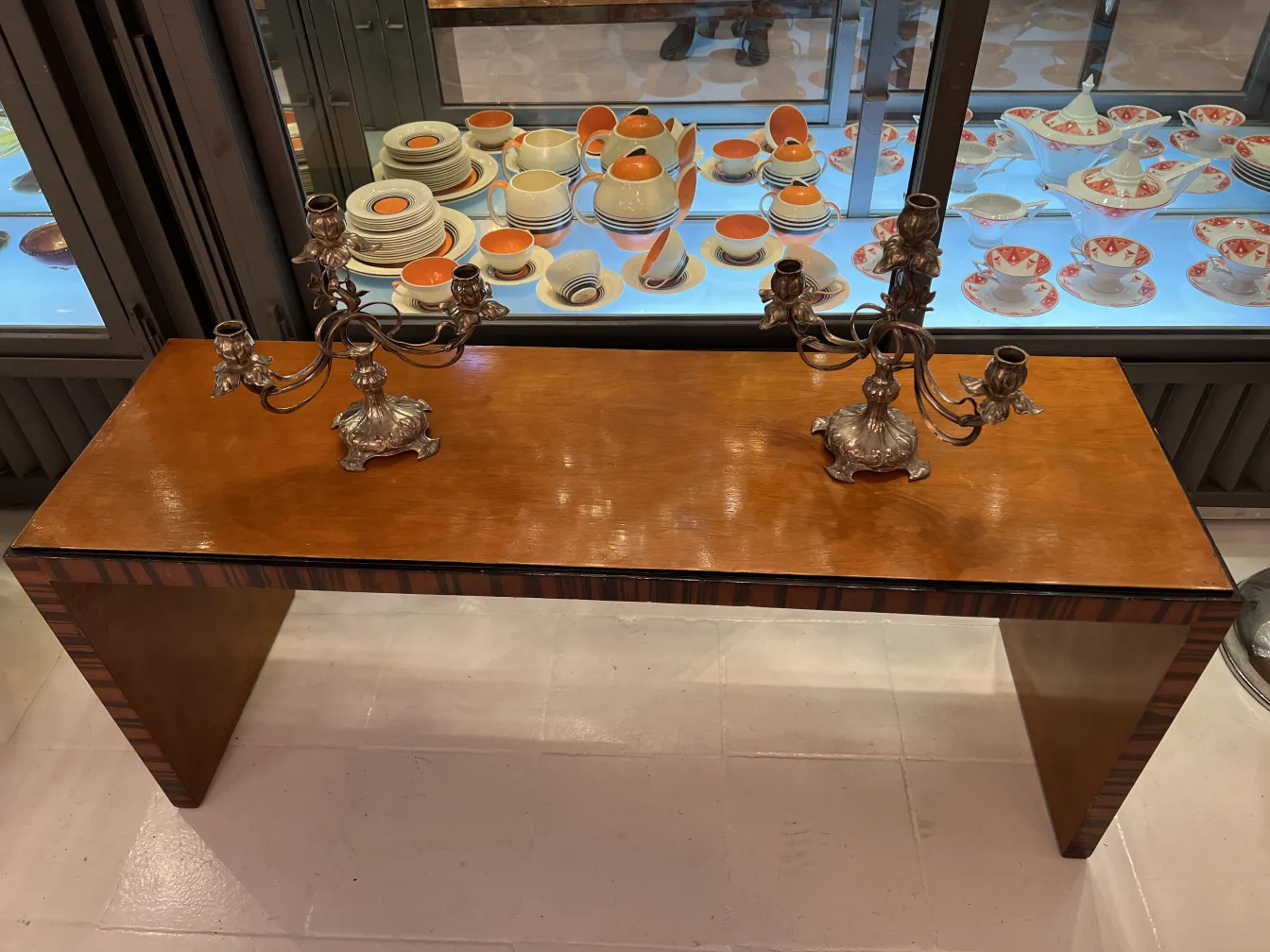 Dos candelabros antiguos decorados, estilo Art Nouveau, en una mesa de madera.