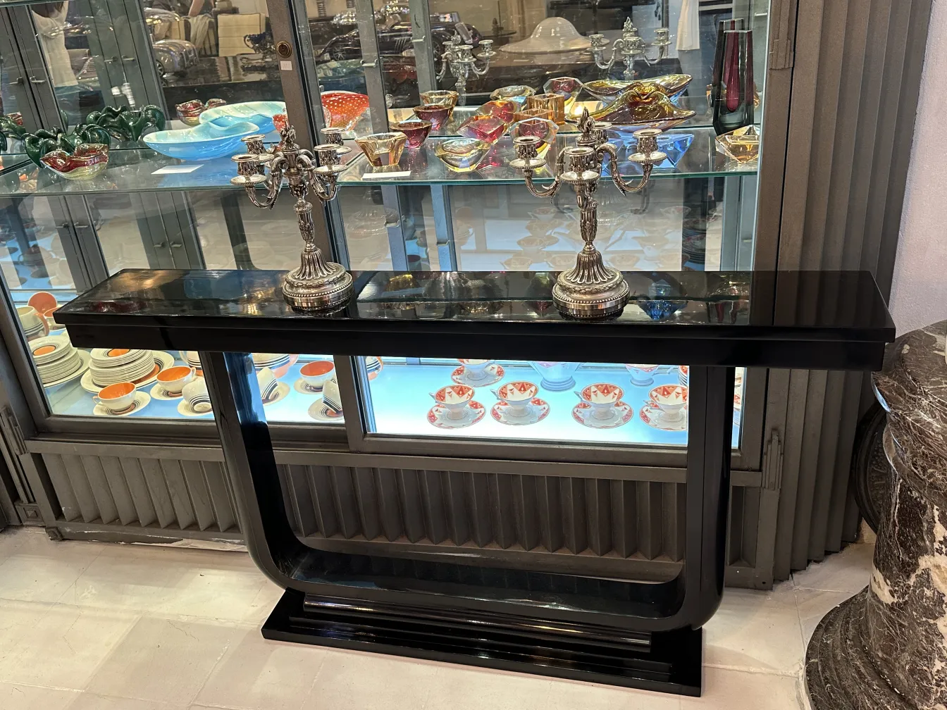 par de castiçais antigos art nouveau em uma mesa com pratos coloridos ao fundo