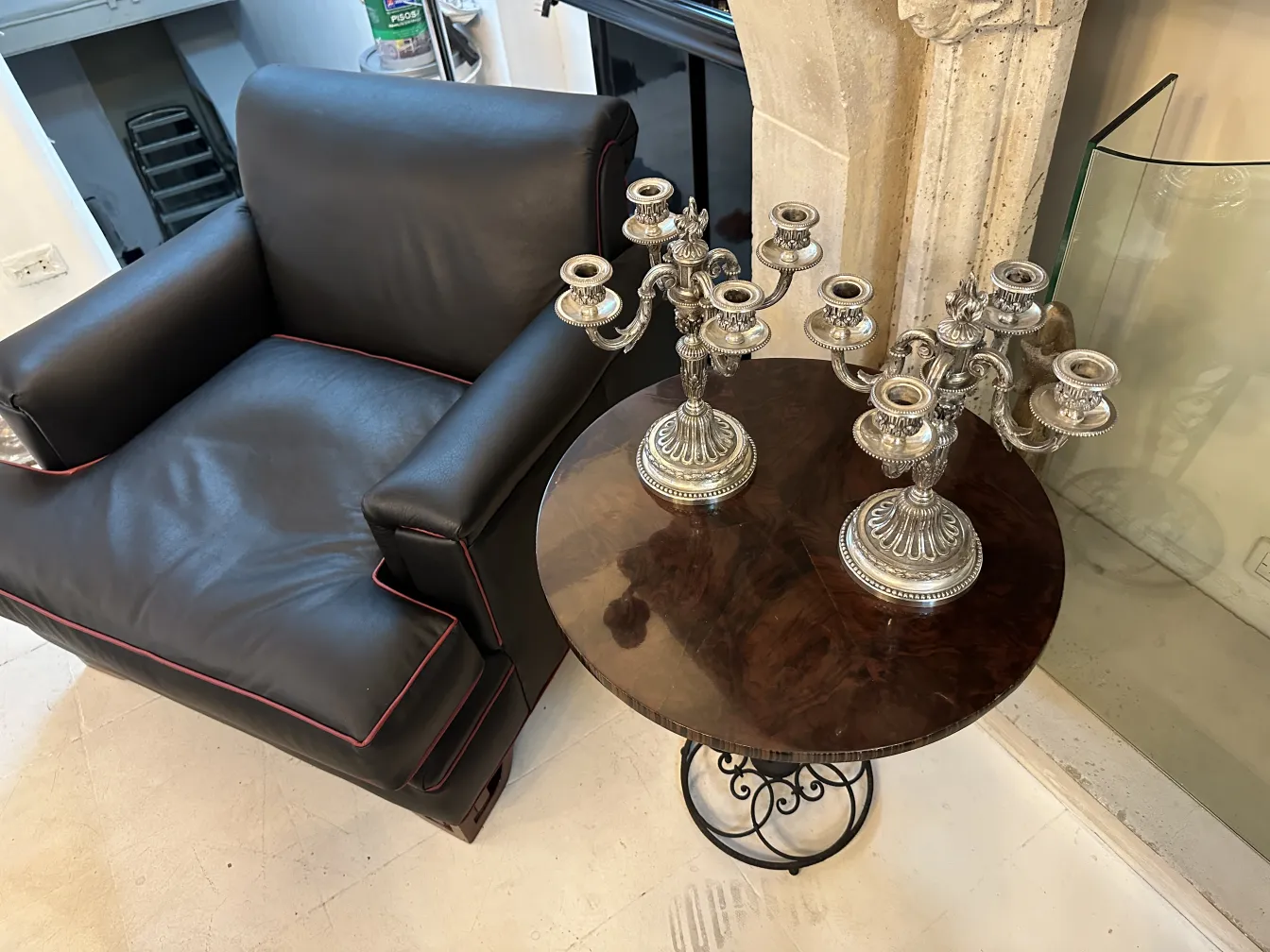 dos candelabros antiguos art nouveau en mesa con sillón negro