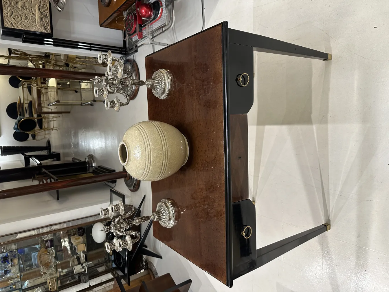 Zwei antike Kerzenhalter in eleganter Umgebung, einer mit aufwendigem Design, der andere schlicht.