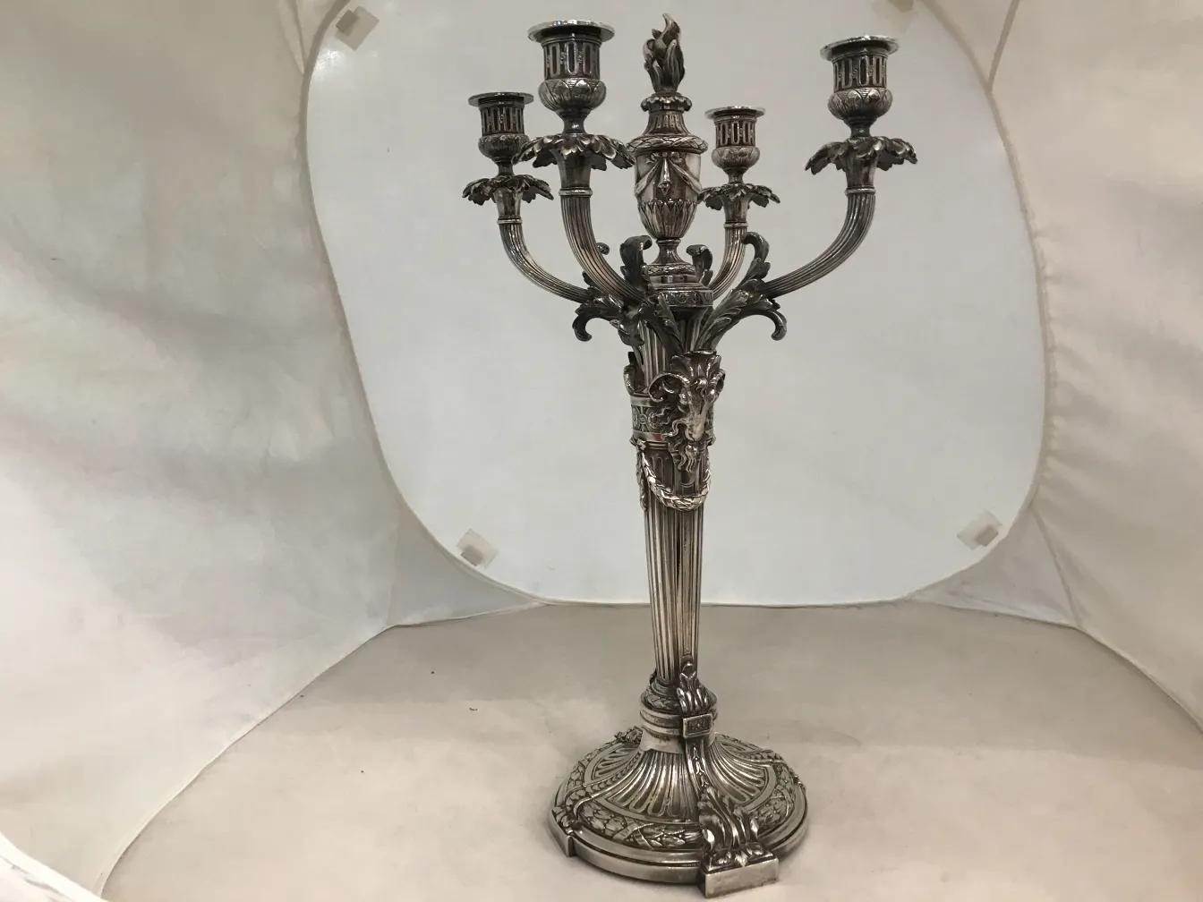 Candélabres anciens au design art nouveau et détails décoratifs dans un cadre neutre.