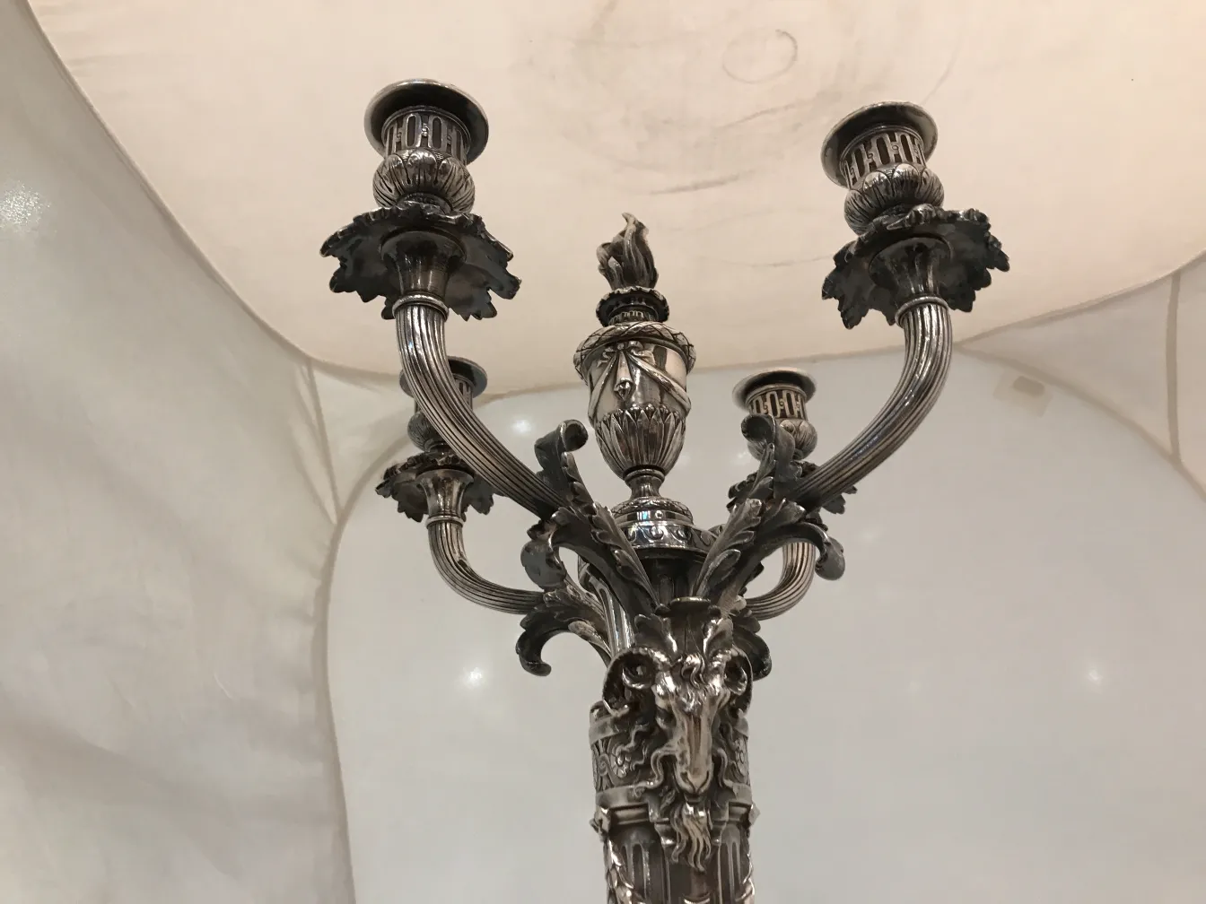 Two antique candelabras with art nouveau details on a light background