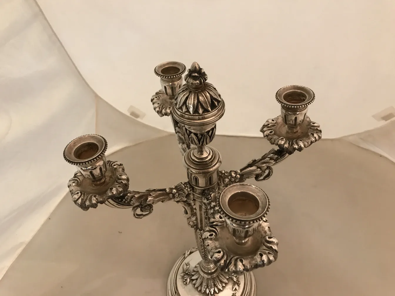 Candelabros antiguos con detalles decorativos en un fondo neutro.