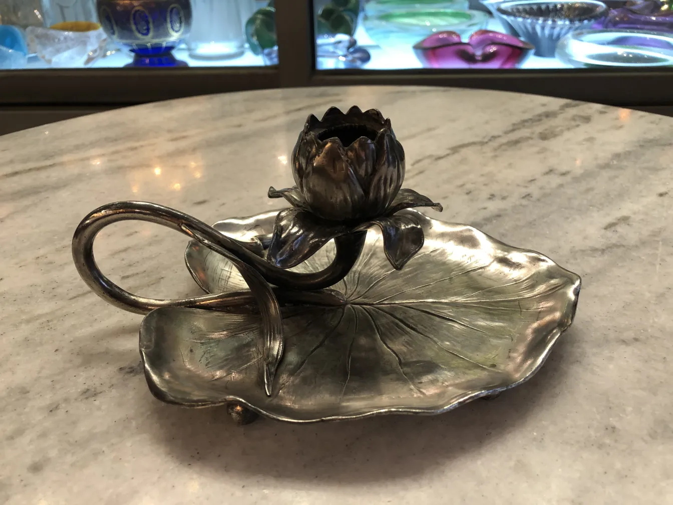 antique candelabra shaped like a lotus flower on a smooth surface