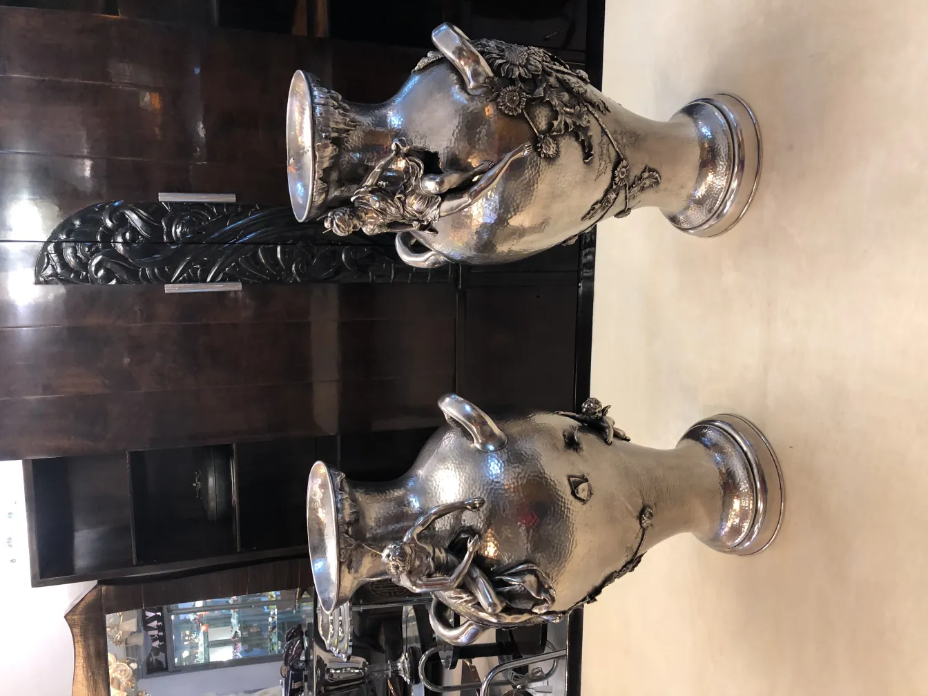 Dois vasos antigos em uma mesa, com detalhes decorativos