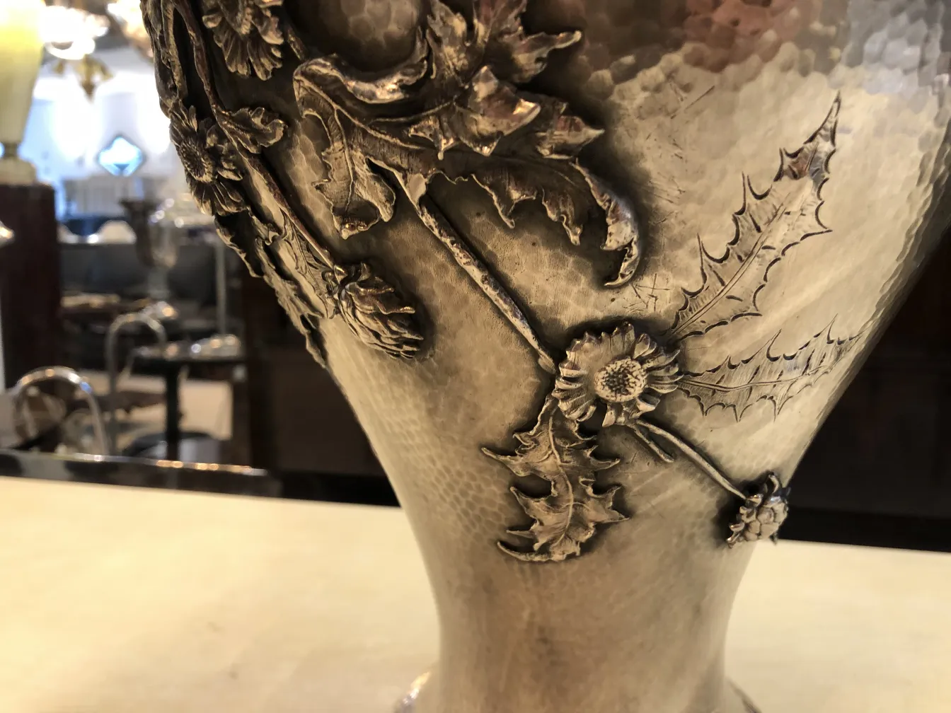 Two antique vases with floral relief decorations Art Nouveau, displayed in an elegant setting.