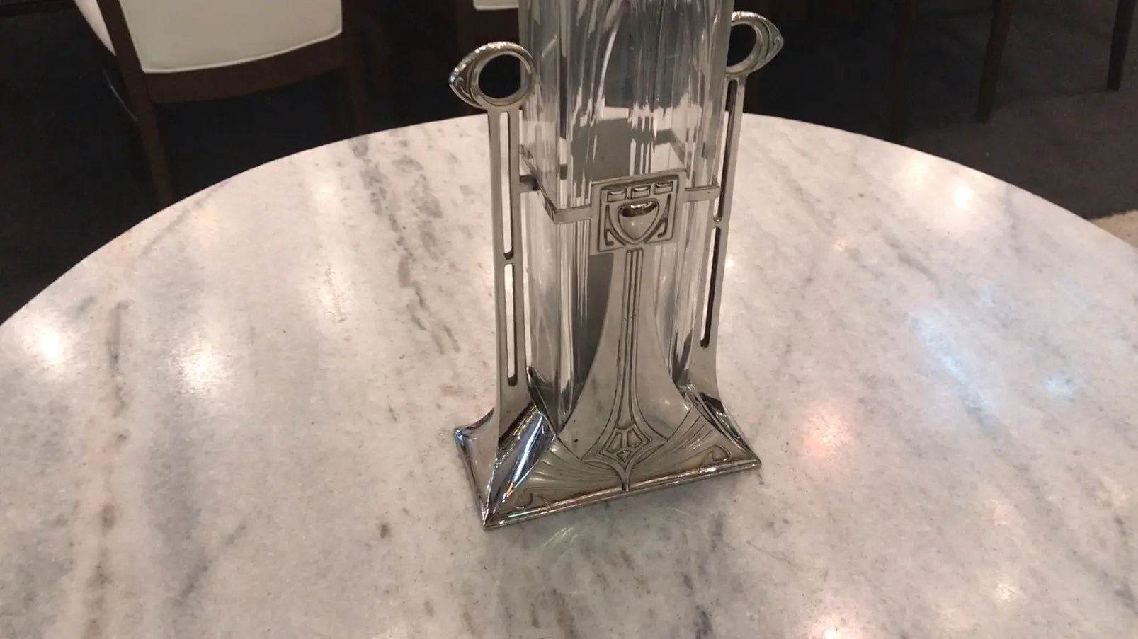 Two antique vases with art nouveau design on a marble table.