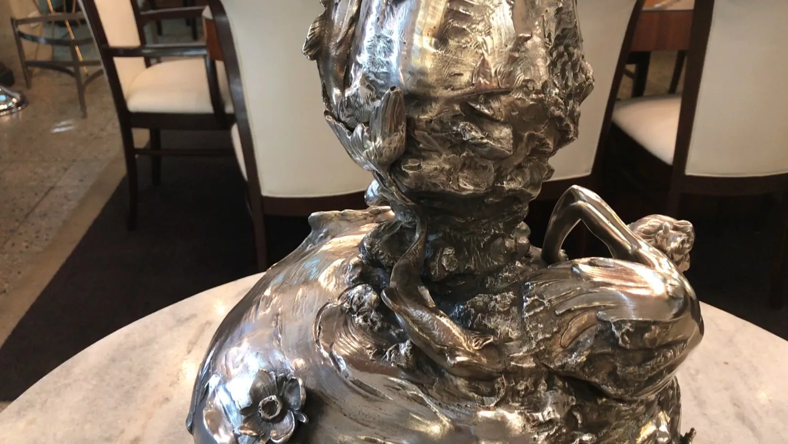 due vasi antichi decorativi con dettagli art nouveau, ambiente elegante, sfondo di sedie moderne