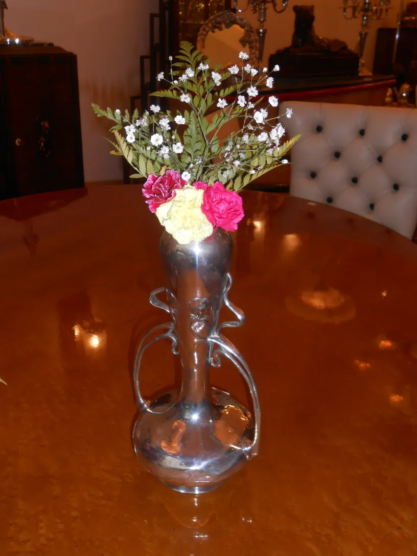 古い花瓶に花が飾られ、クラシックな空間に置かれています。