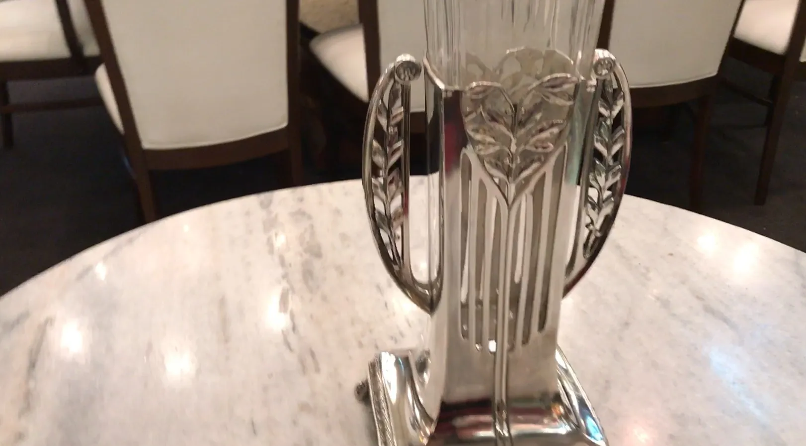 Deux vases anciens au design Art Nouveau, décorés de feuilles, sur une table en marbre.