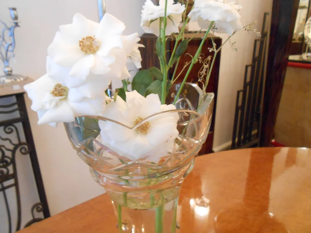 Dos floreros antiguos de cristal con flores blancas