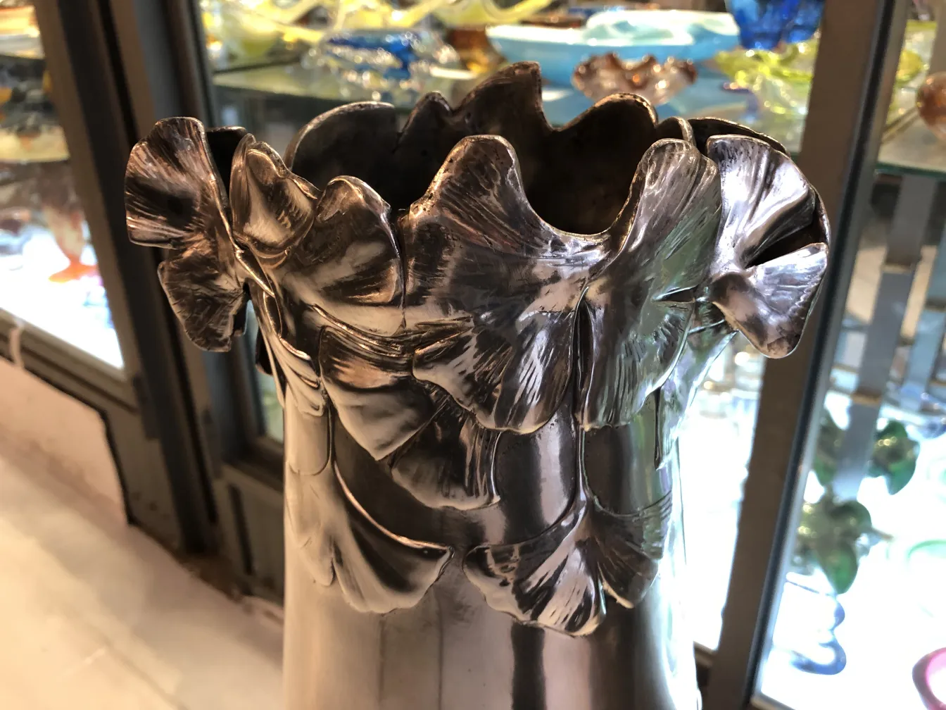 vase ancien avec bords ondulés et feuilles sculptées, fond flou