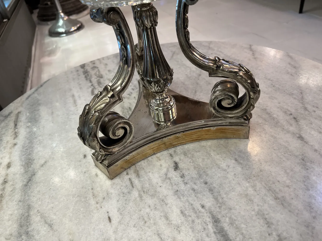 Vaso antico con base decorativa e dettagli in stile art nouveau in un ambiente elegante.