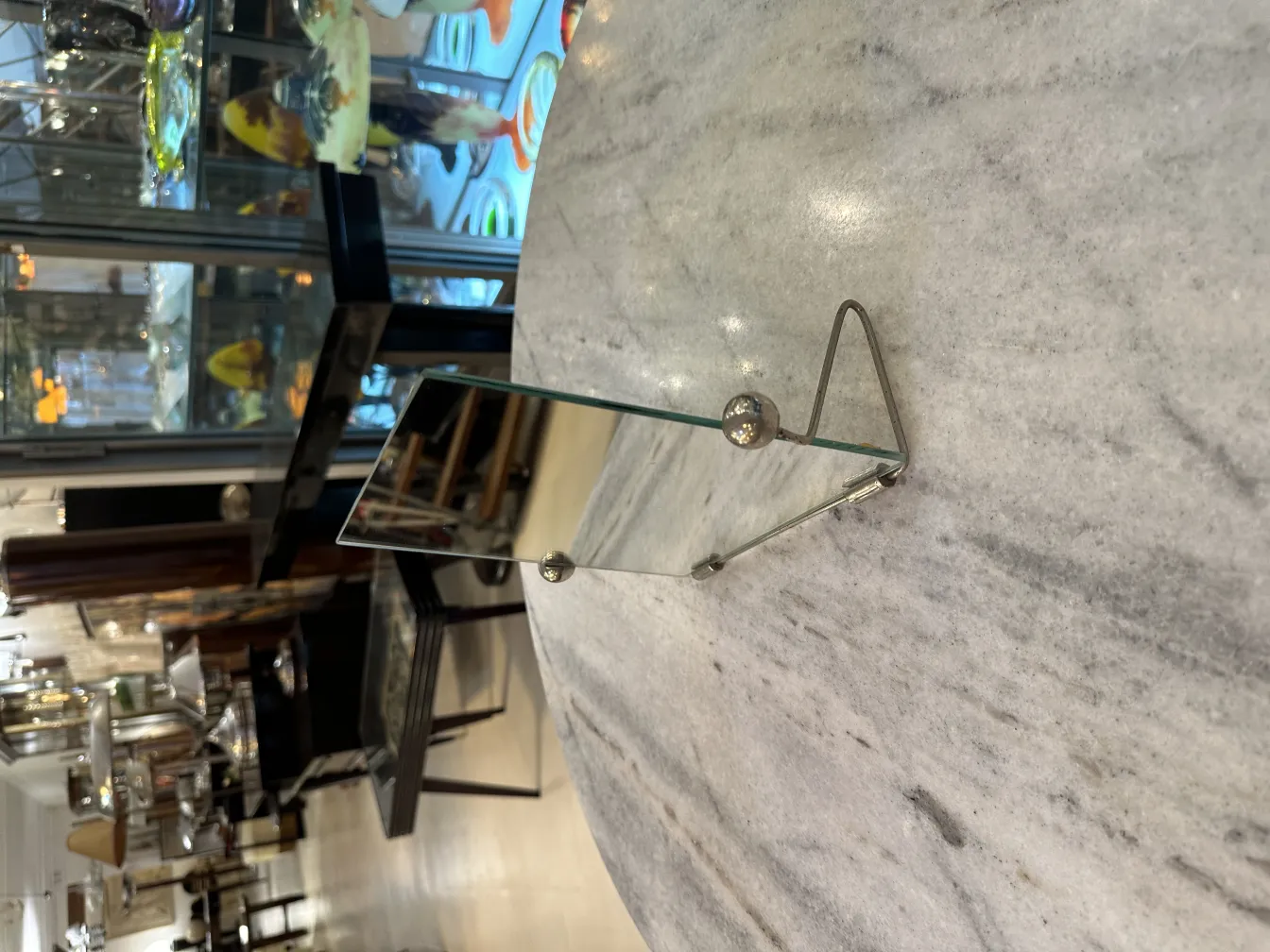 espelho antigo com suporte, refletindo um ambiente elegante