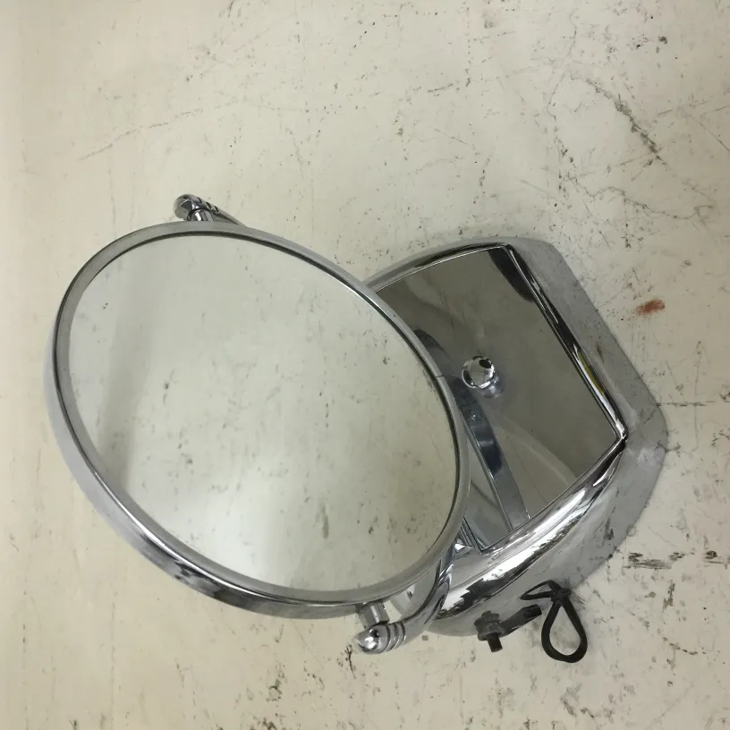 Antique bathroom mirror with round frame and silver base.