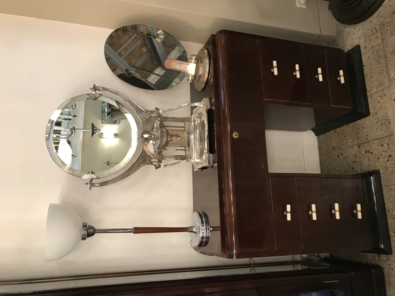 espejo antiguo con estilo art nouveau sobre una cómoda, rodeado de luz