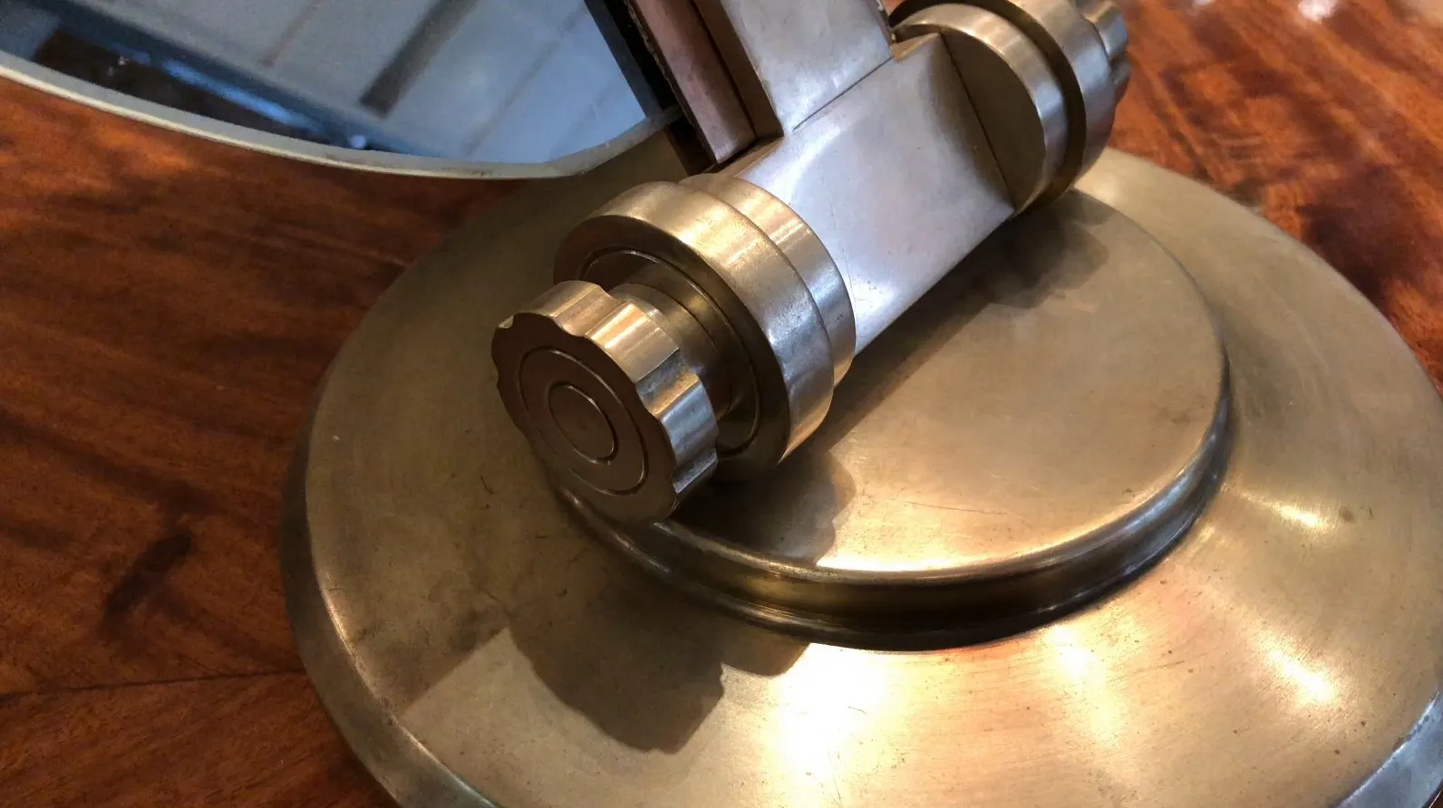 مرآة قديمة بآلية أنيقة وقاعدة خشبية دائرية