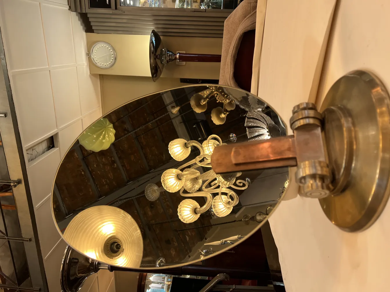 Espelho antigo com suporte, ambiente iluminado, estilo Art Nouveau.