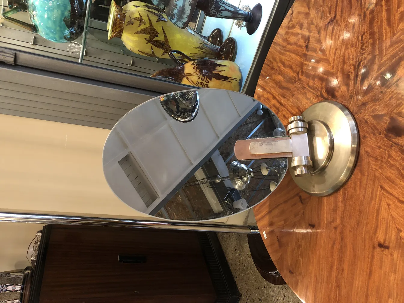 مرآة قديمة بشكل بيضاوي مع قاعدة معدنية في بيئة كلاسيكية