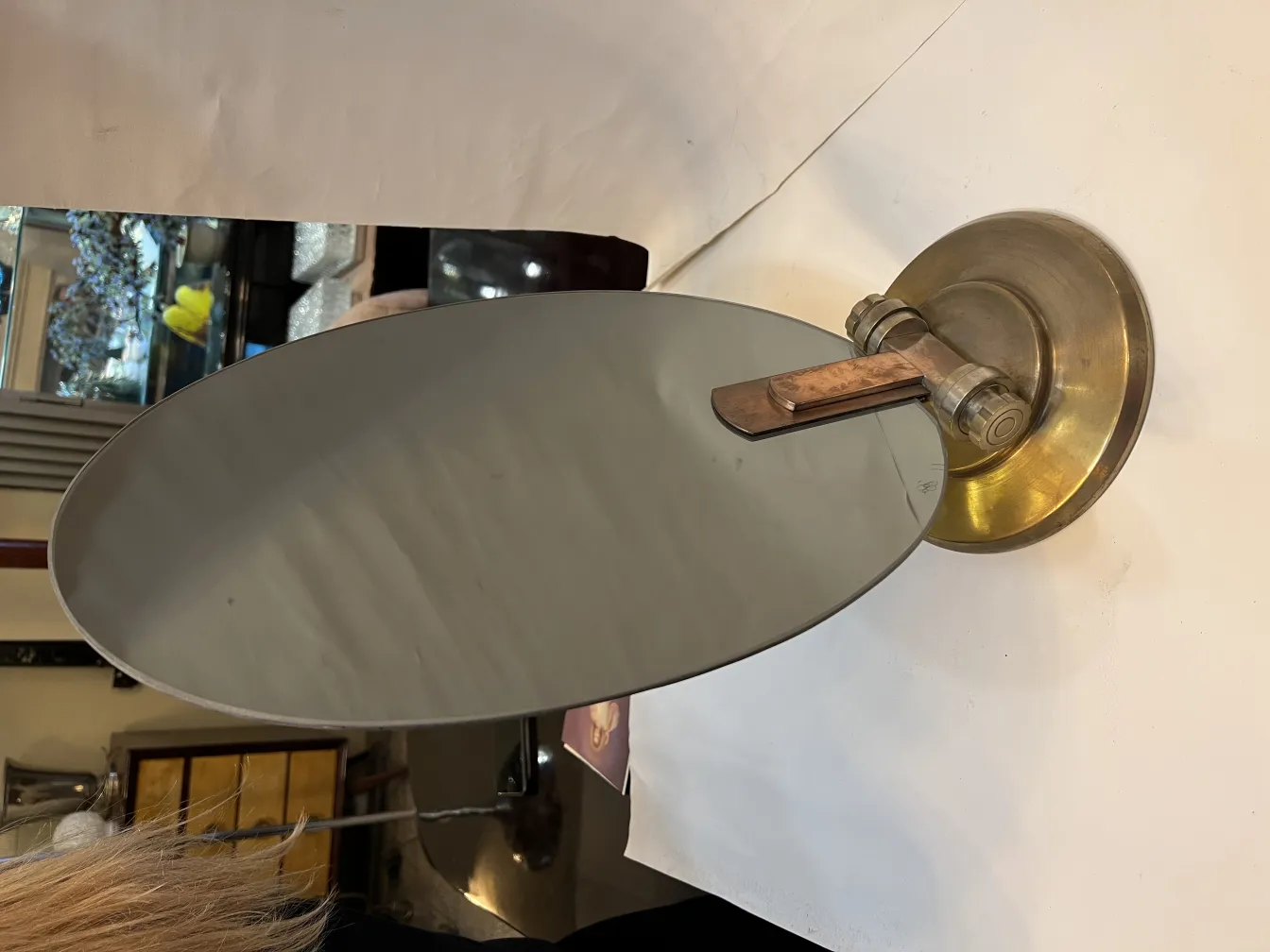 Antikes ovales Spiegel mit Metallhalter in einem Vintage-Umfeld.