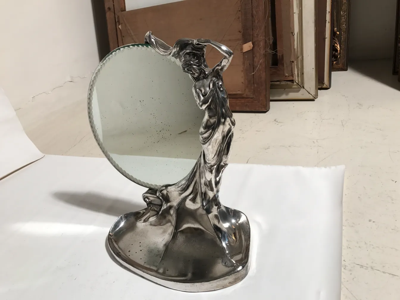 Espejo antiguo Art Nouveau con figura estilizada en pie, fondo neutral