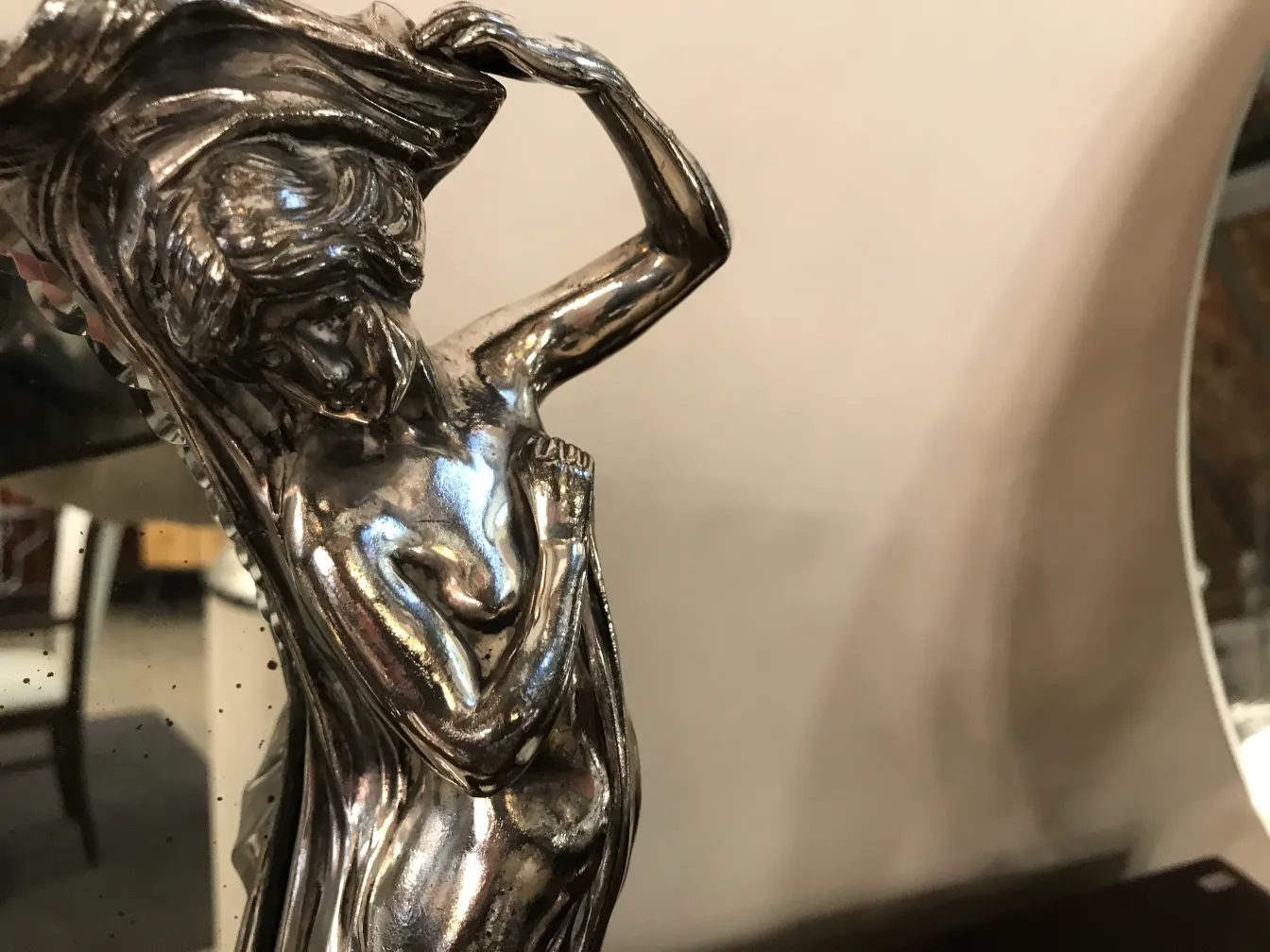 espelho antigo com detalhes femininos na moldura