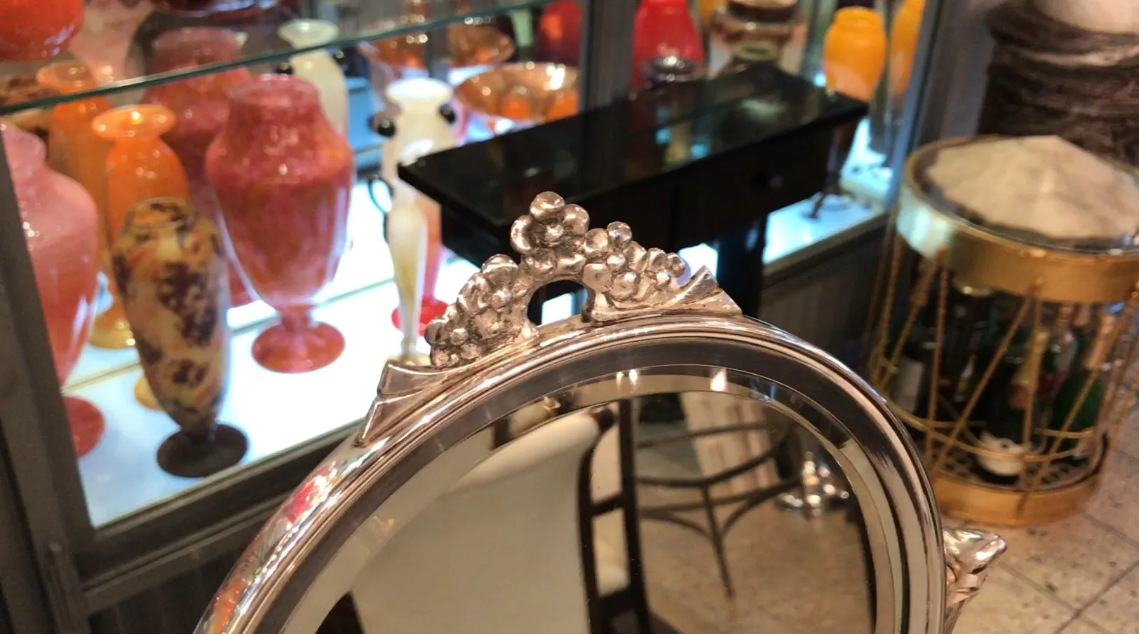 antique mirror with floral details at the top, in an antique setting