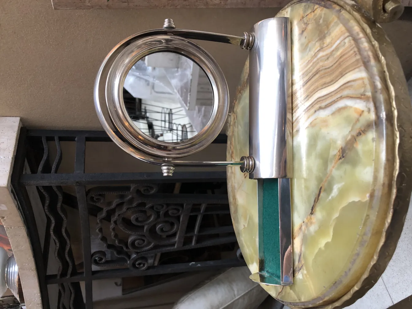 miroir ancien avec design élégant et base artistique, placé sur une surface décorative.