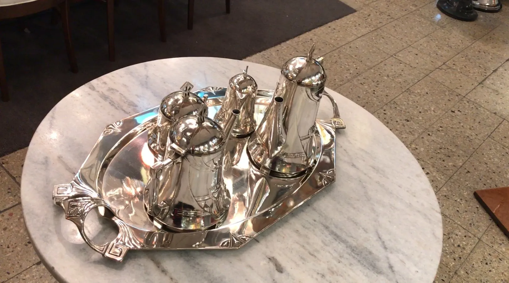 Conjunto de chá antigo WMF com várias chaleiras em uma mesa de mármore.