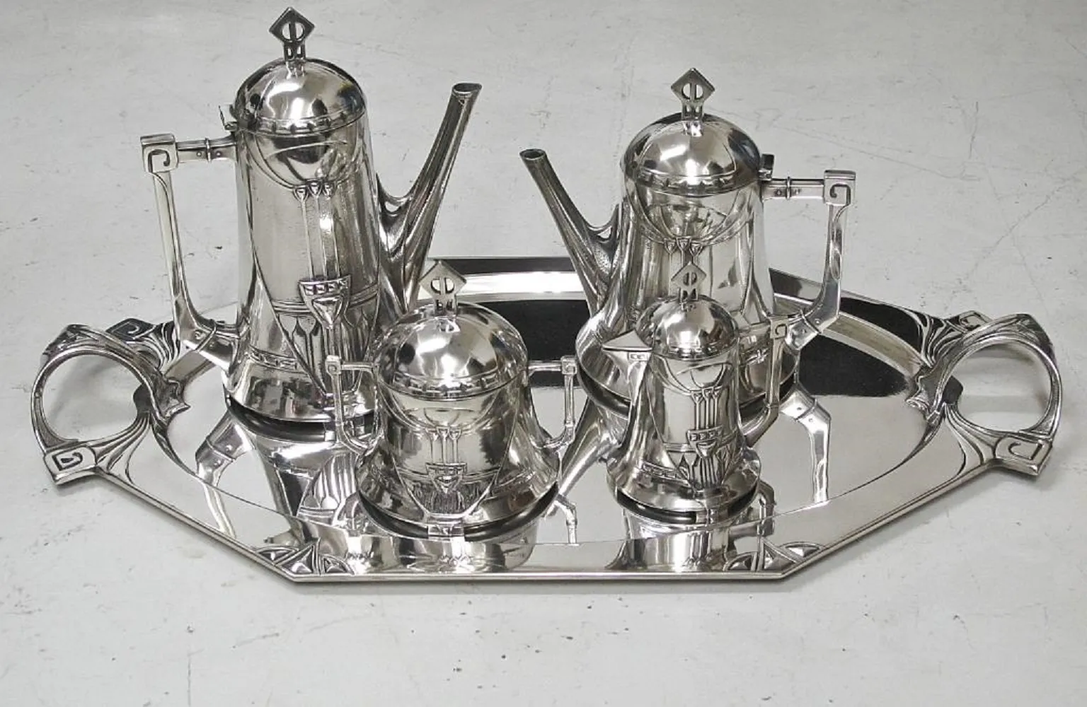Antique WMF tea set with teapot and reflective tray.