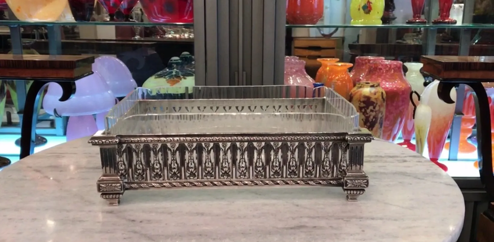 jardinera antigua christofle con detalles decorativos en un entorno de antigüedades coloridas