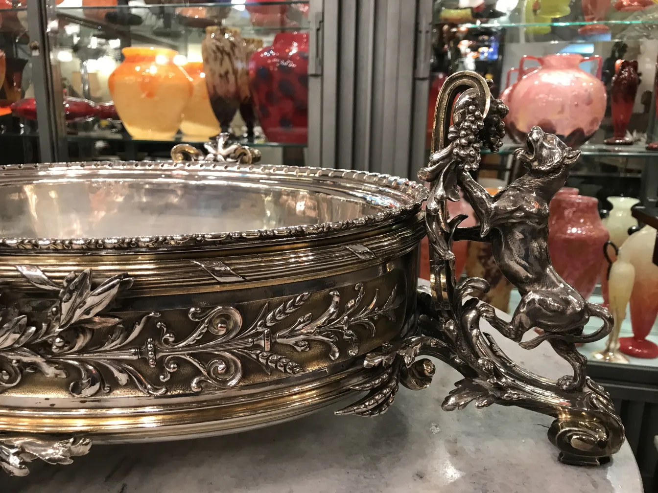 centrotavola antico con dettagli elaborati e un cane come supporto circondato da decorazioni colorate.