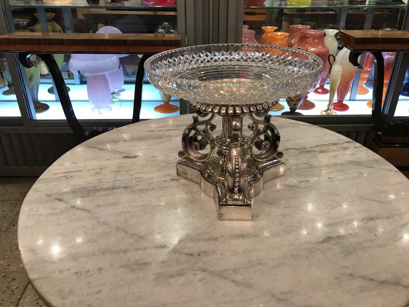 古董中心装饰品 Christofle 放置在大理石桌上，周围环绕着收藏品