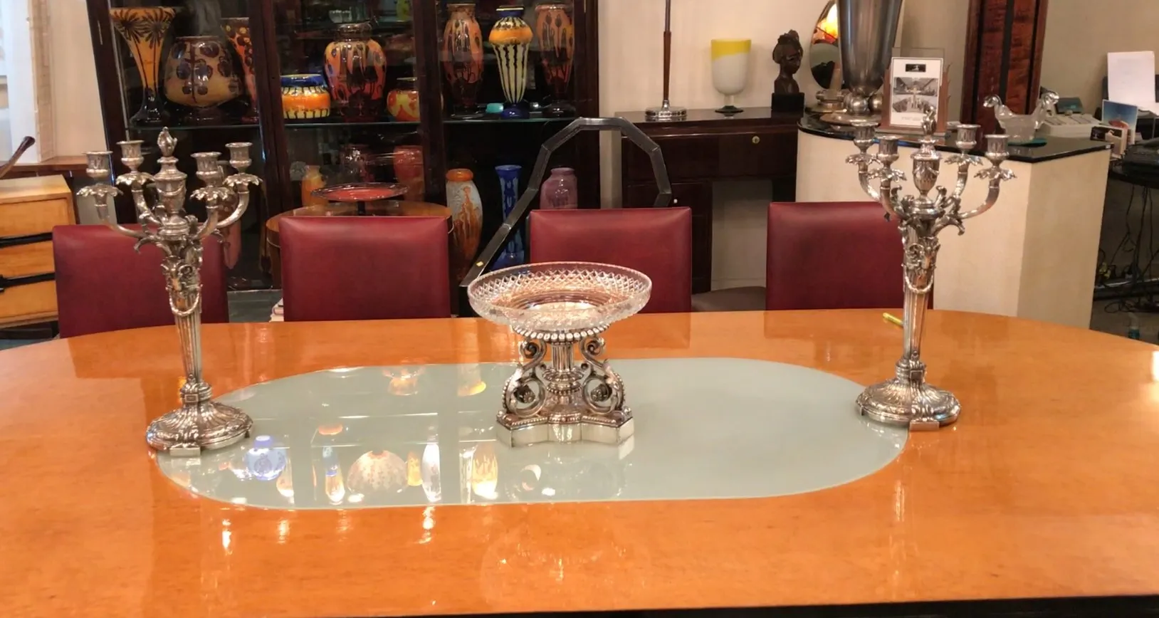 Antiker Tischdeko Christofle auf einem eleganten Tisch mit Candelabrum und bunten Dekorationen im Hintergrund.