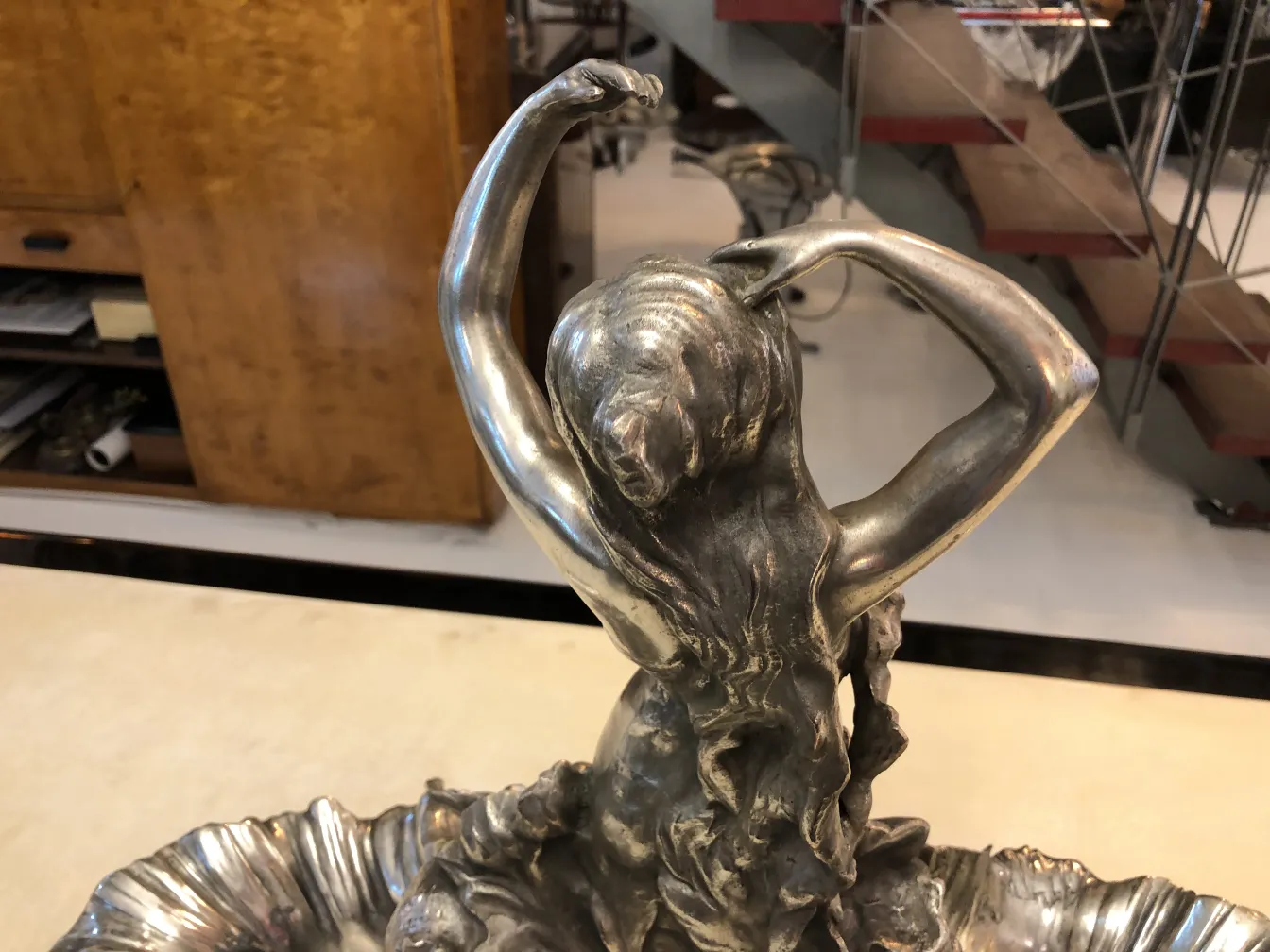 centro de mesa antigo com figura feminina e detalhes decorativos