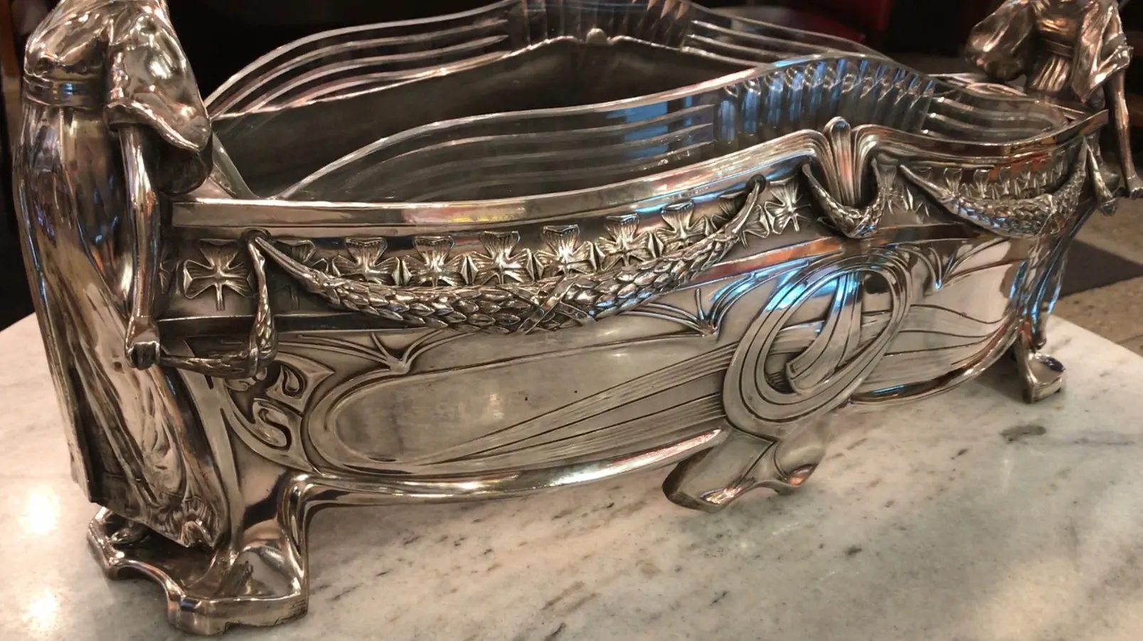 Centrotavola WMF con dettagli ornamentali e figure decorative, su una superficie in marmo chiaro