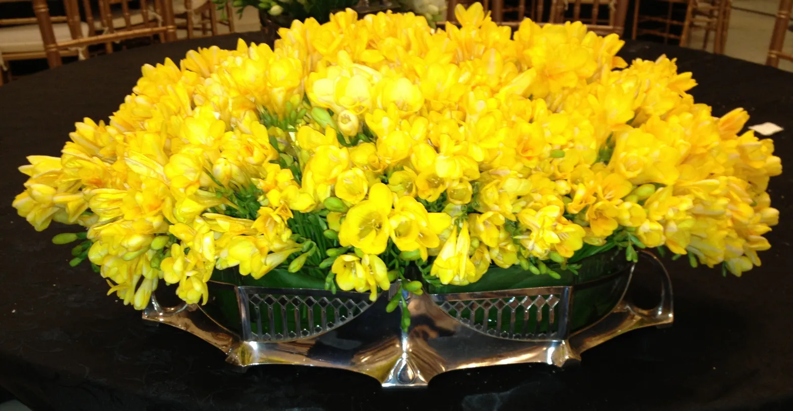 Centre de table antique WMF avec des fleurs jaunes, décoration élégante.