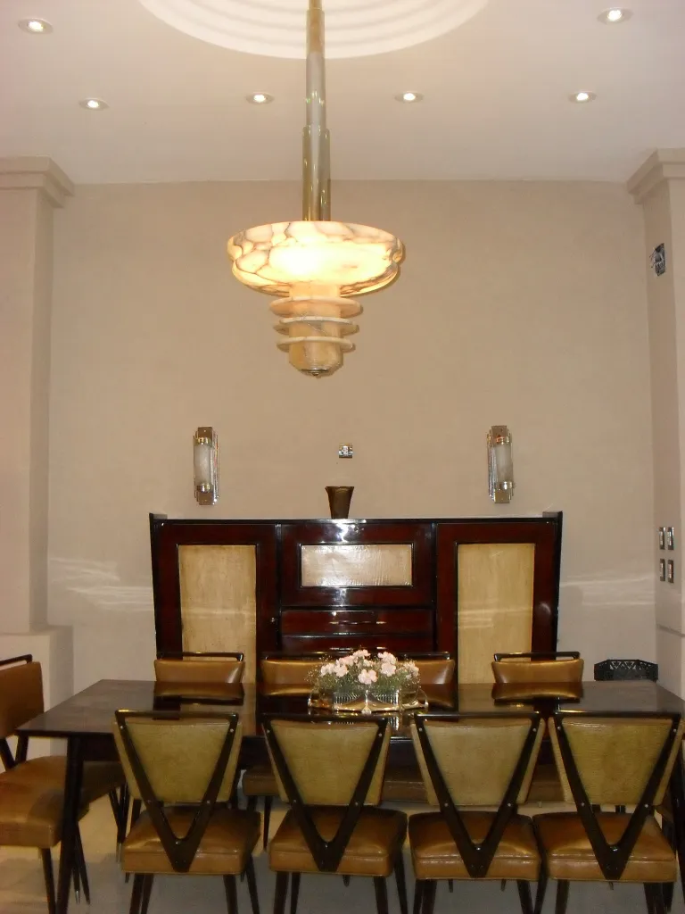WMF centerpiece on dining table with chairs, adorned with flowers