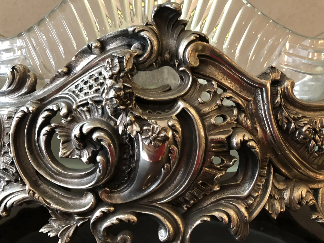 Centre de table WMF ancien avec des décorations détaillées et élégantes, entouré d'un cadre classique.