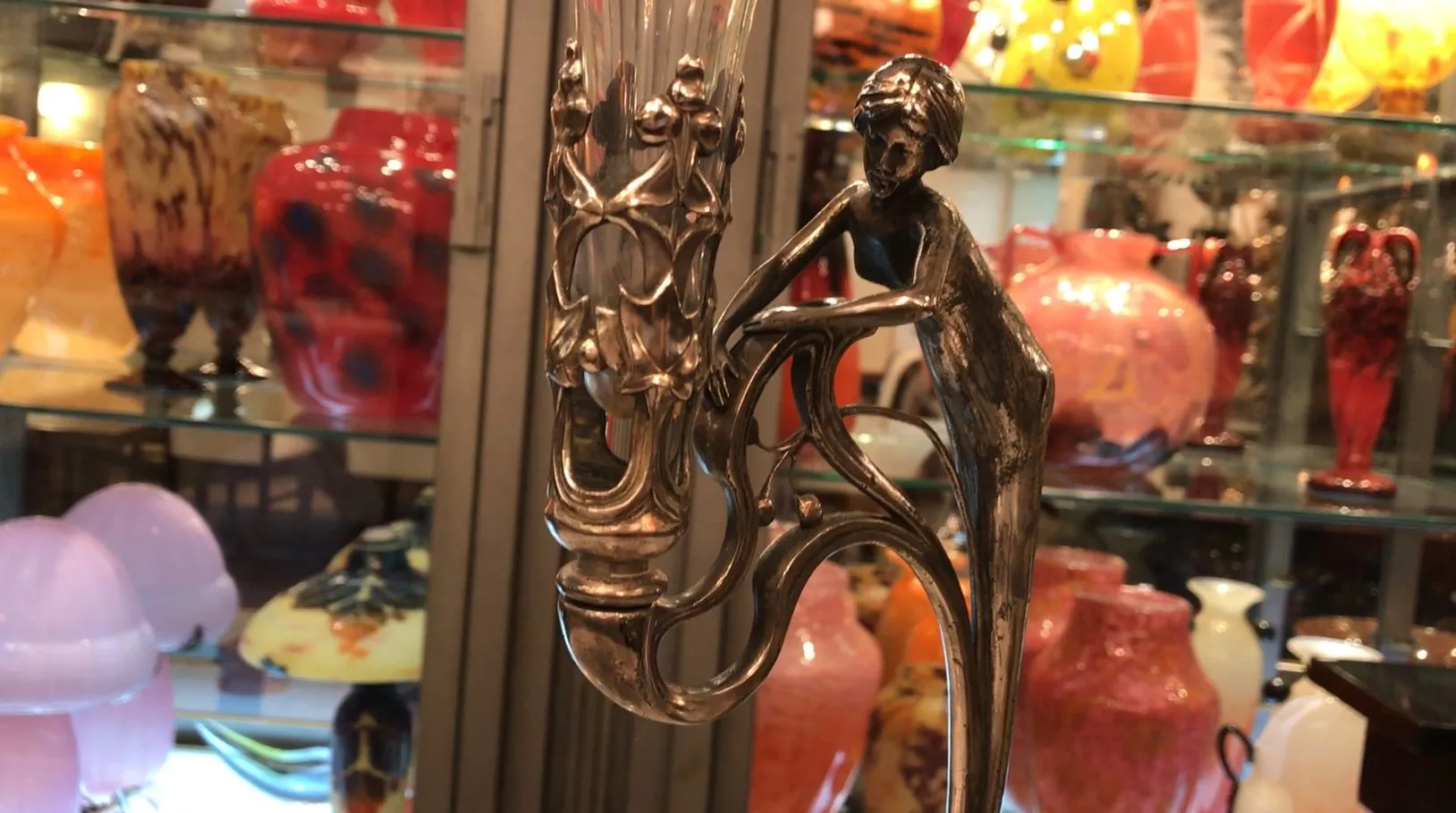 Centro de mesa WMF antigo com figura decorativa em um ambiente colorido.