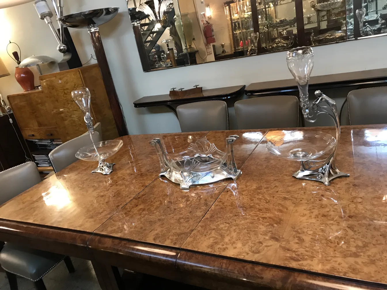 Centrotavola antico WMF su tavolo di legno, circondato da decorazioni.