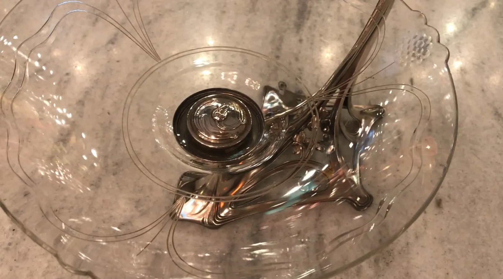 Ancien centre de table WMF avec des détails décoratifs en spirale sur une surface en marbre