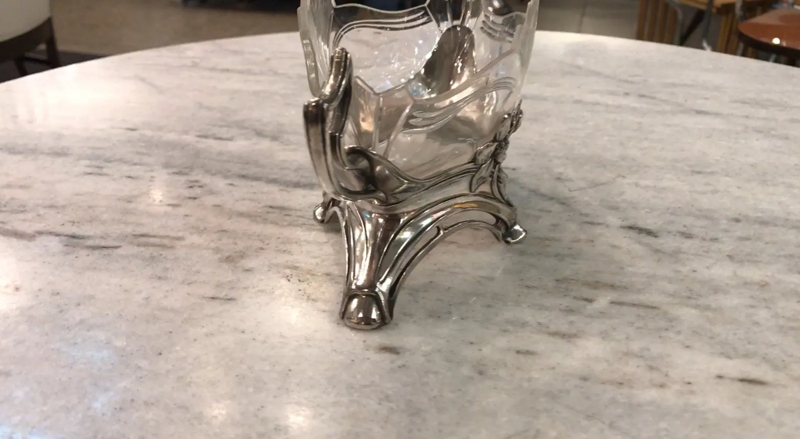 Antique WMF centerpiece with elegant design on marble table.