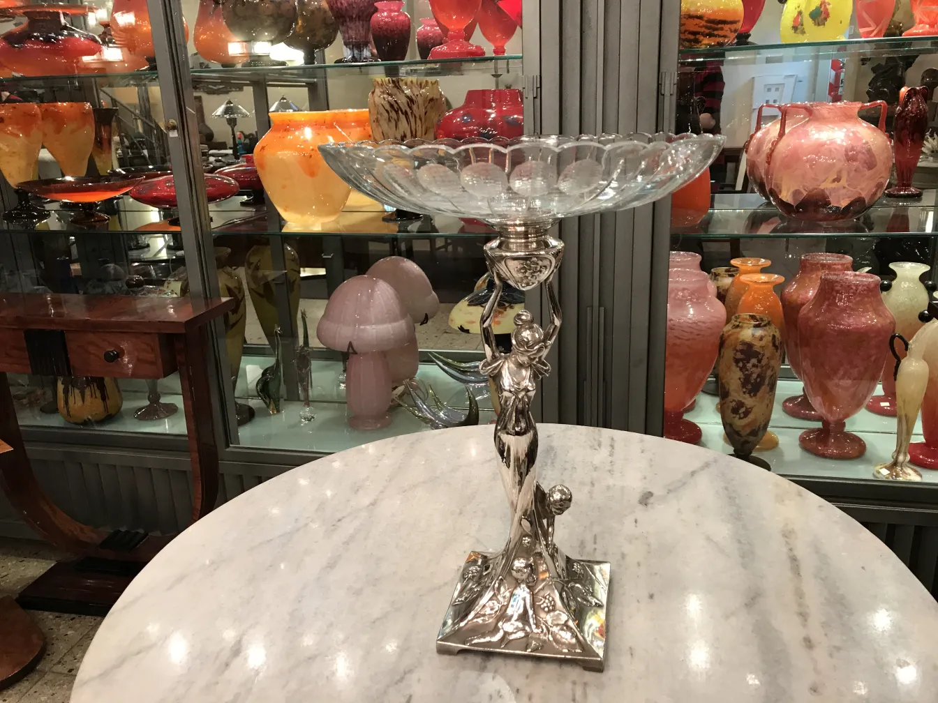 Jardinera WMF en una mesa con antigüedades alrededor