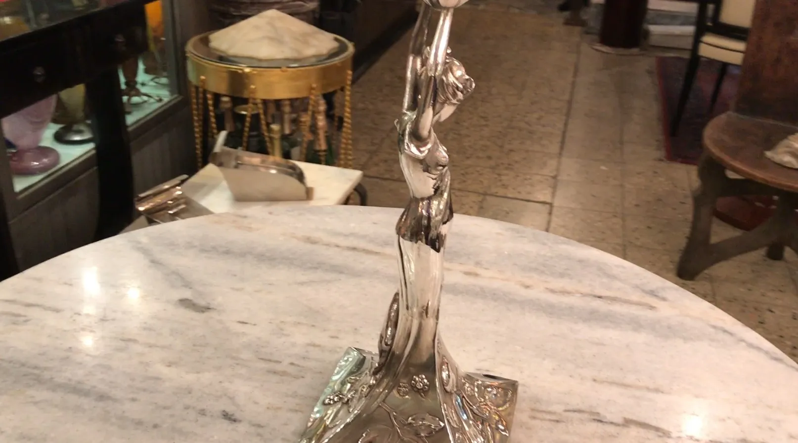 jardinera WMF antigua con figura decorativa elegante, ambiente cálido, detalles florales