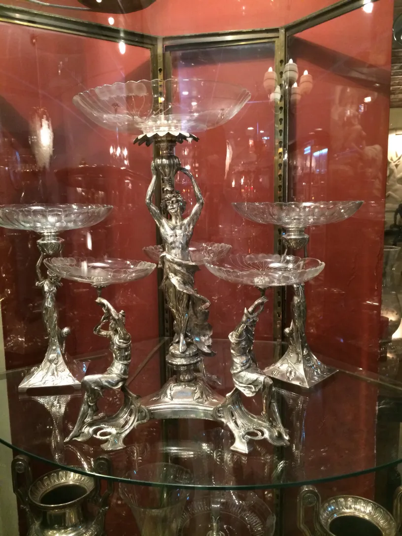 centro de mesa antigo com figuras decorativas e pratos