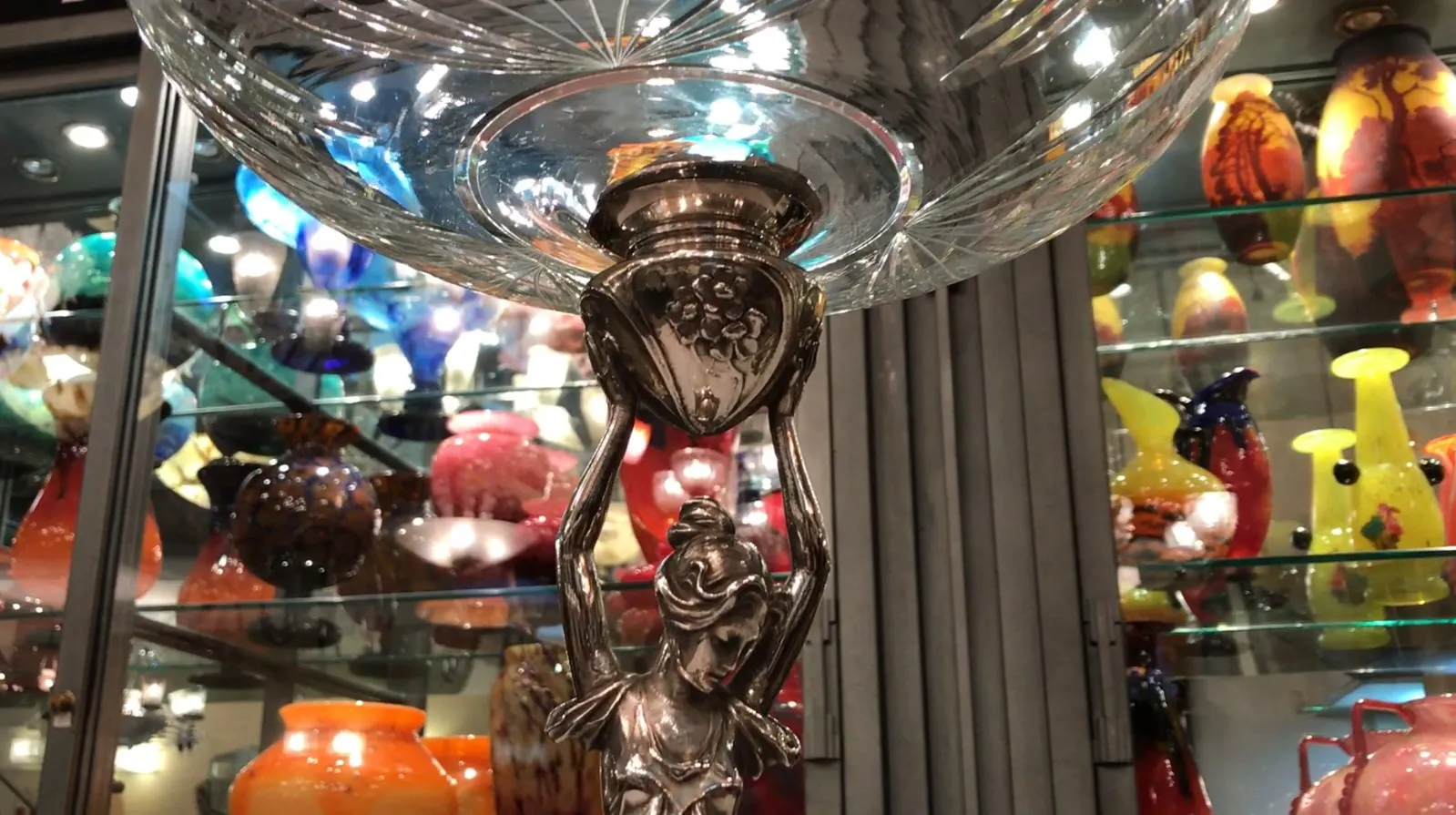 Centre de table ancien WMF avec finition élégante et design décoratif, entouré de vases colorés.