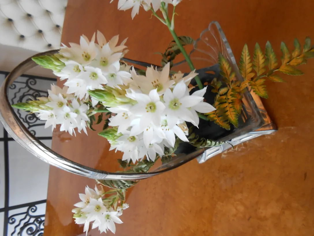antique WMF centerpiece with white flowers and green foliage in an elegant setting
