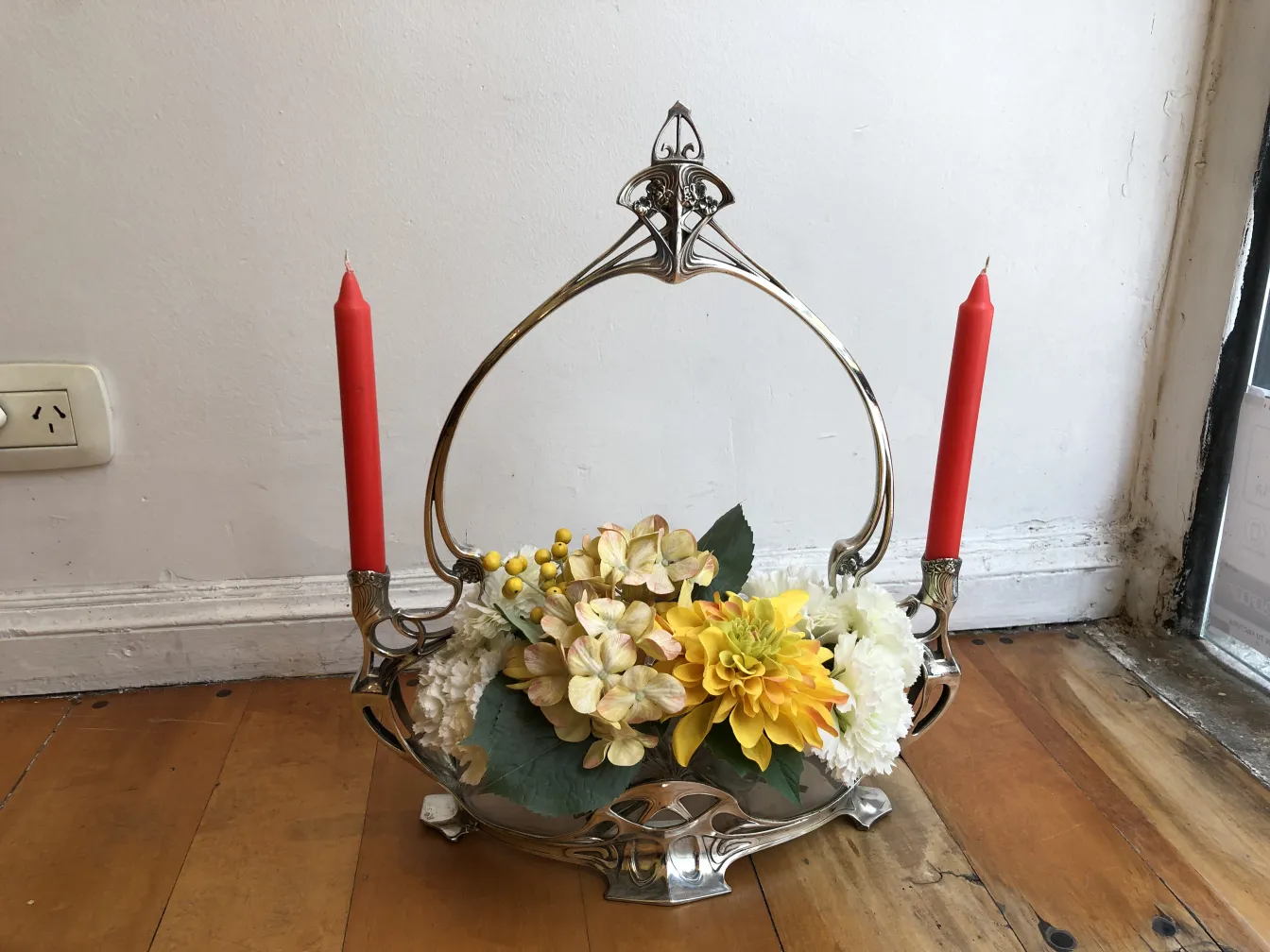 Antiker dekorativer Blumentopf mit Blumen und roten Kerzen.